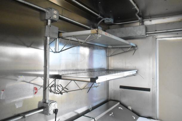 Interior of ATX 24' food trailer, showing stainless steel shelving and electrical outlets, clean and ready for use.