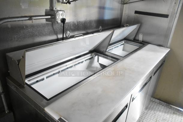 ATX 24' food trailer interior with Arctic Air prep tables, open lids, and stainless steel finish, ideal for mobile kitchen use.
