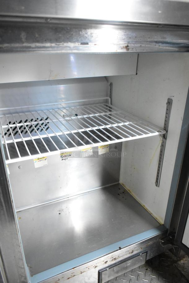 Interior of ATX 24' food trailer fridge, stainless steel shelves, labeled compartments, commercial-grade.