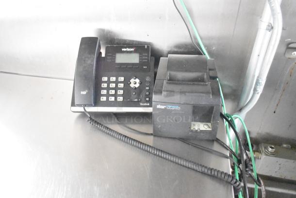 Yealink office phone and Star TSP100III thermal printer in food trailer, indicating communication and order processing setup.