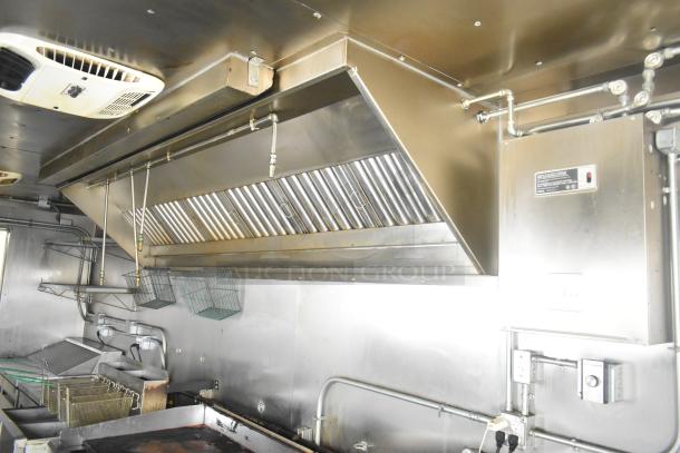 ATX 24' food trailer kitchen with commercial grease hood, fire suppression system, fryers, and stainless steel fixtures.