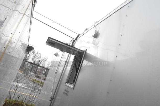 ATX 24' food trailer exterior, rain-streaked, open service window, labeled "We Do Not Carry Cash," commercial-grade kitchen inside.