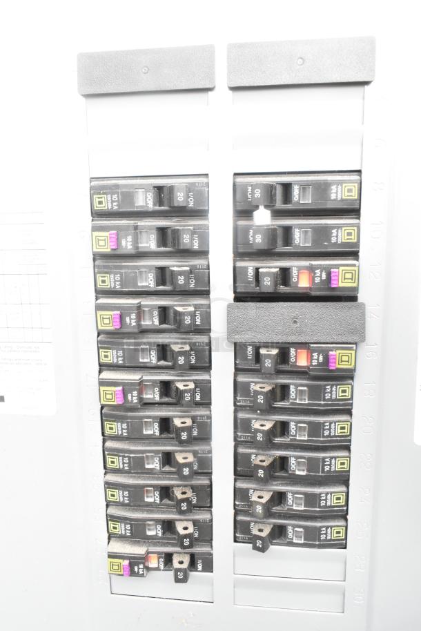 Electrical panel with multiple labeled circuit breakers, including switches for appliances and safety systems.
