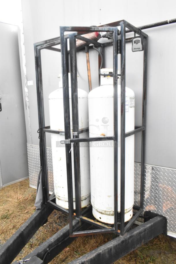 ATX 24' food trailer with propane tanks secured in black metal cage, exterior view. Ideal for a mobile kitchen setup.