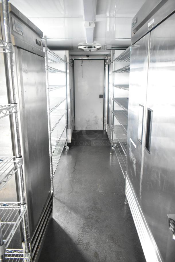 Southern Dimensions 24' cold food trailer interior with True reach-in coolers, freezers, sinks, and wire shelving.