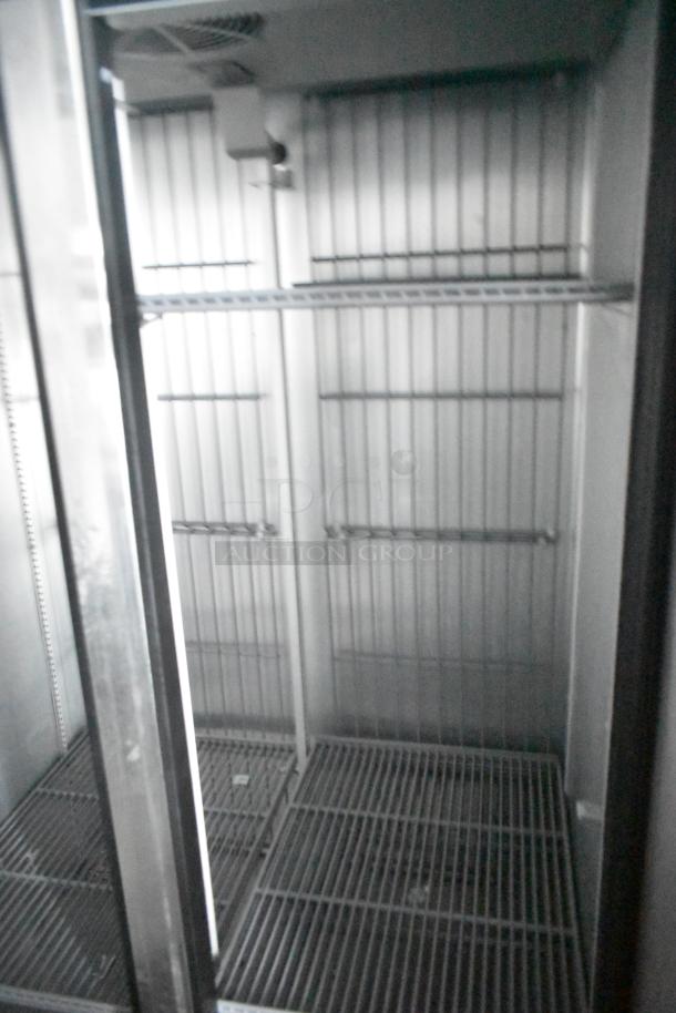 Interior of a True reach-in cooler with wire shelving inside a 2021 Southern Dimensions 24' outfitted food trailer.