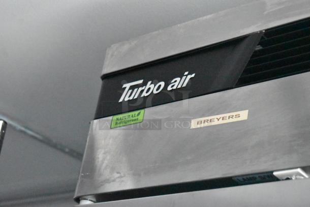 Close-up of Turbo Air cooler with "Natural Refrigerant" and "BREYERS" labels on stainless steel finish.