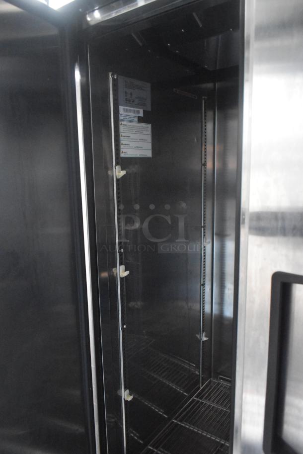 Interior view of a Norlake 2-door cooler inside a Southern Dimensions 24' food trailer, showcasing shelves and labels.