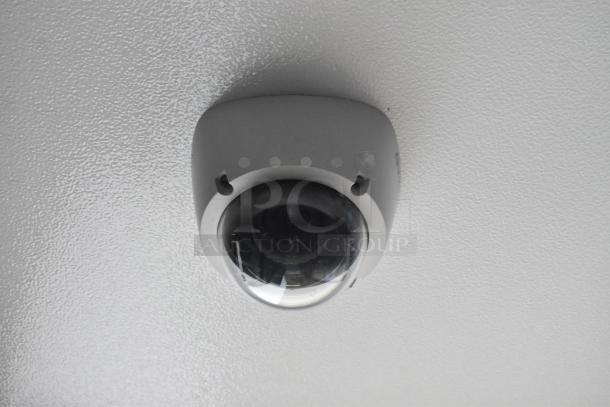 Ceiling-mounted dome security camera with a black lens cover.