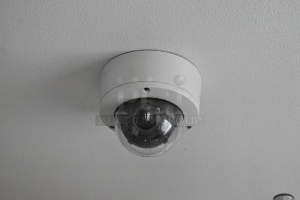 Ceiling-mounted security camera with a black dome cover and a white base.