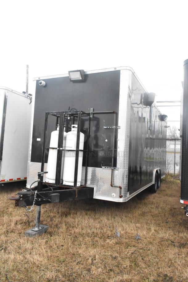2021 ATX 24' outfitted food trailer, black exterior, propane tanks attached, fully equipped with commercial-grade kitchen gear.