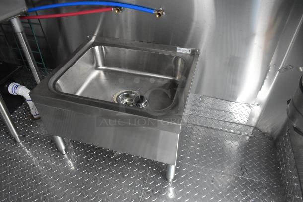 Stainless steel sink inside ATX 24' food trailer with diamond plate flooring, visible pipes, and wall mount connections.
