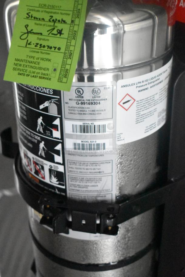 Wet chemical fire extinguisher with UL listings and model K01-3. Green tag with registration details attached.