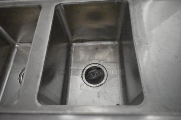 Stainless steel sink with drain, part of a fully equipped 24' ATX food trailer kitchen, ready for commercial use.