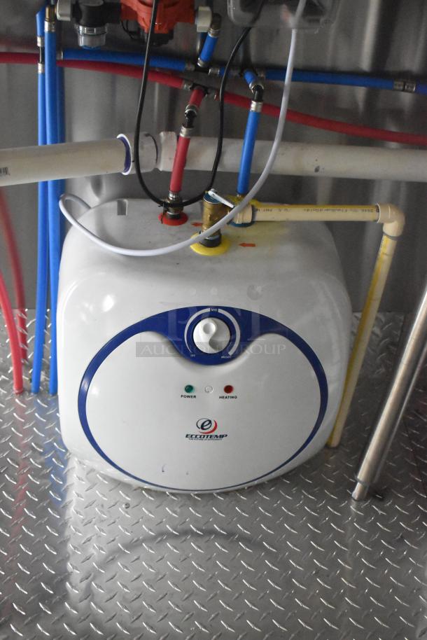Eccotemp water heater in ATX 24' food trailer. Features power and heating indicators. Mounted on diamond plate flooring.