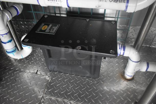 ATX 24' food trailer interior showing Ashland grease trap and piping, set on diamond plate flooring.