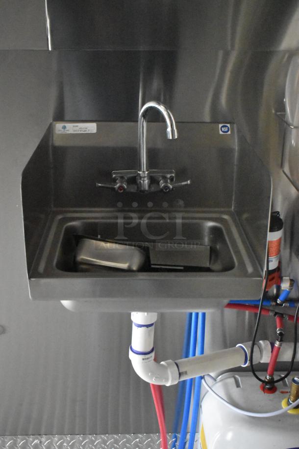 Commercial-grade stainless steel sink with dual faucets inside the 2021 ATX 24' mobile food trailer, featuring NSF certification and plumbing connections.