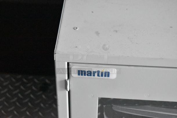 Industrial metal cabinet with "martin" logo, featuring a hinged door. Suitable for commercial use or storage.