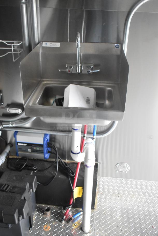 Stainless steel sink in ATX 24' food trailer, featuring dual faucet and plumbing underneath, NSF certification visible.