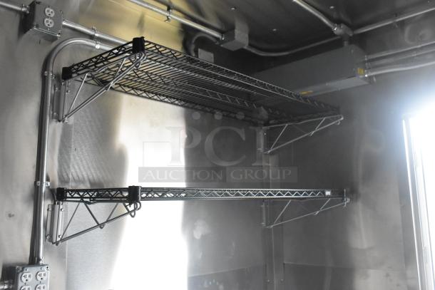 Interior view of 2021 ATX 24' food trailer showing wire shelving units, electrical outlets, and stainless steel walls.