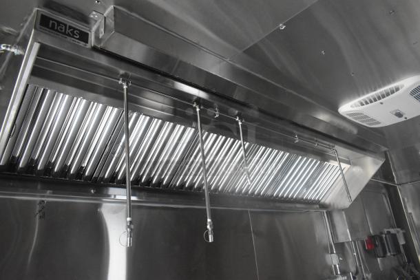 ATX 24' food trailer's Naks grease hood and fire suppression system, commercial-grade kitchen setup, new condition.