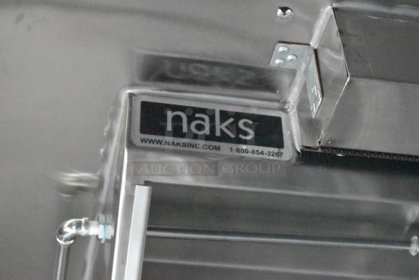 Naks grease hood label in ATX 24' food trailer, featuring www.naksinc.com and contact number, part of commercial equipment setup.