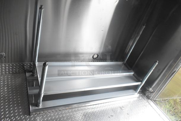 ATX 24' food trailer interior with metal wire shelving and diamond plate flooring. New condition, commercial-grade setup.