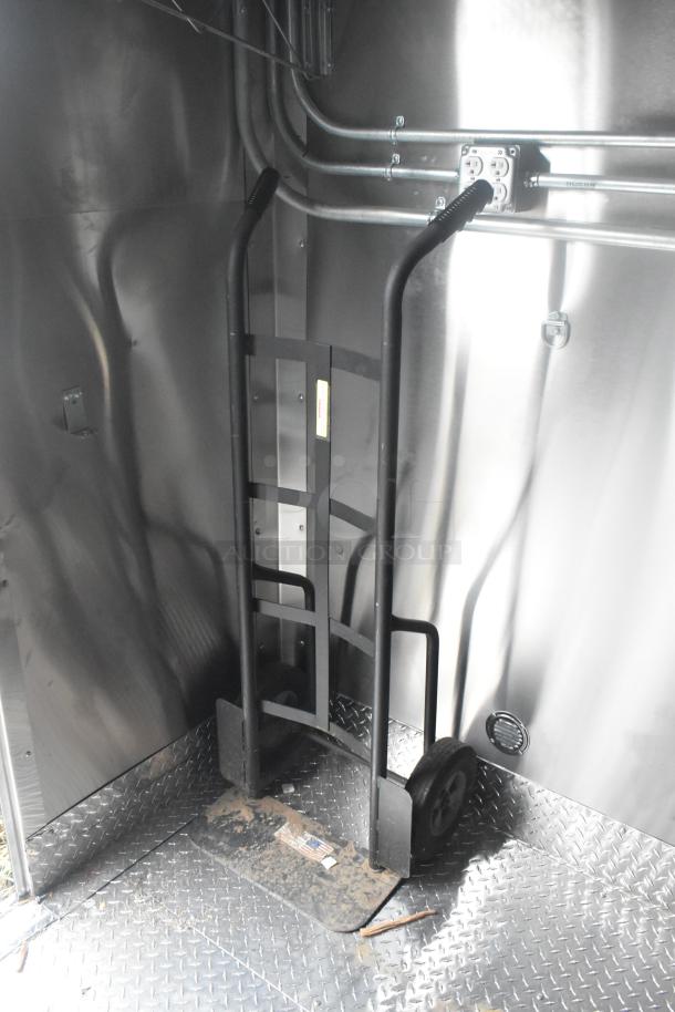 Interior of ATX 24' food trailer featuring a dolly, metal walls, and diamond plate flooring. Suitable for mobile kitchen setup.