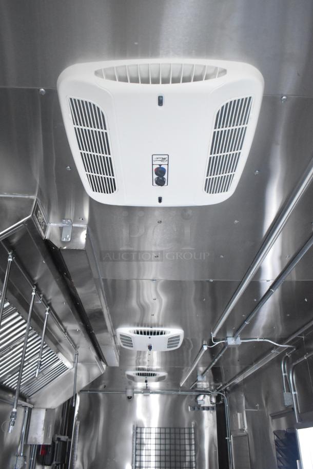 Interior of an ATX 24' food trailer showing Naks grease hood, ventilation system, and stainless steel fittings.