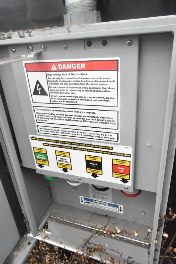 Electrical panel in the ATX 24' food trailer. Includes danger warning labels for high voltage risk.