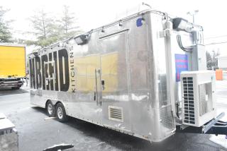 Cruising Kitchens 24' mobile food trailer, metallic finish, branded with NBRHD Kitchens, equipped for commercial use.