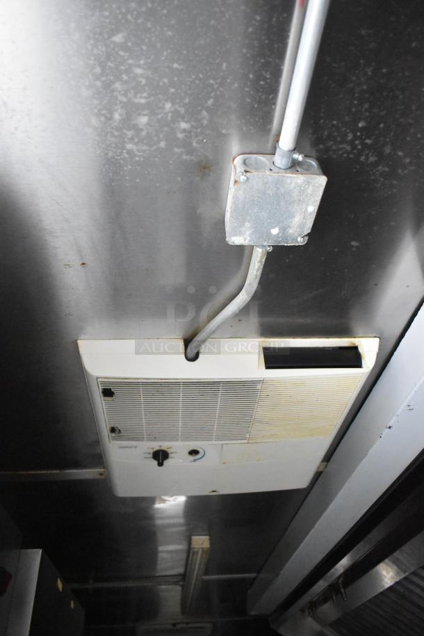 Inside view of a Cruising Kitchens food trailer showing a ceiling-mounted ventilation system and electrical conduit.