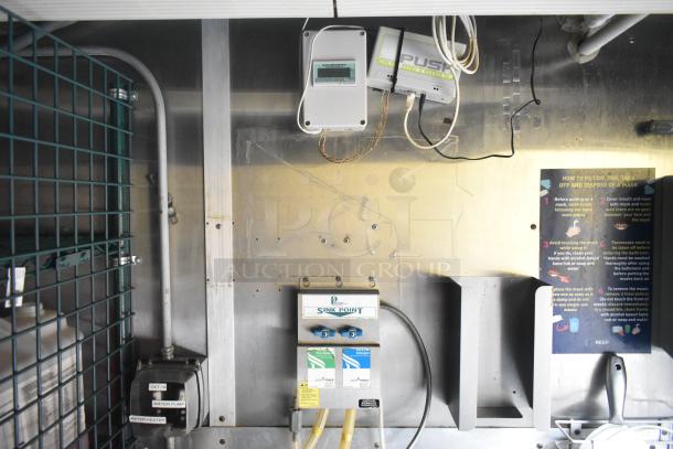 Cruising Kitchens 24' food trailer interior, showing water pump and sink point controls. Marked with instructions and wiring.