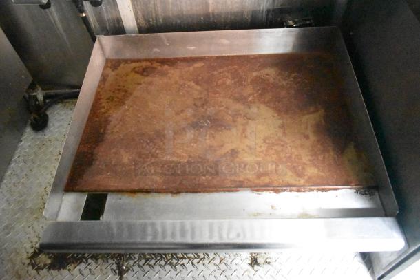 Rustic flat-top grill inside the Cruising Kitchens 24' food trailer, showcasing commercial-grade cooking equipment.