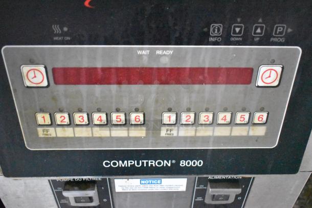 Control panel of Computron 8000 with numbered buttons and display. Includes heat indicators and function labels.