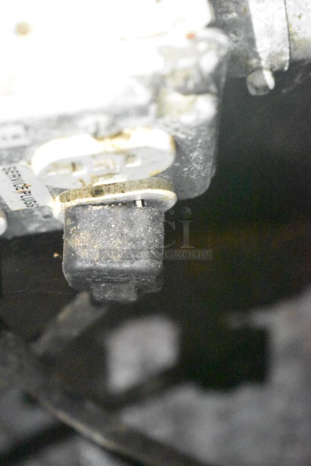 Close-up view of a service plug in the Cruising Kitchens food trailer, showing wear.