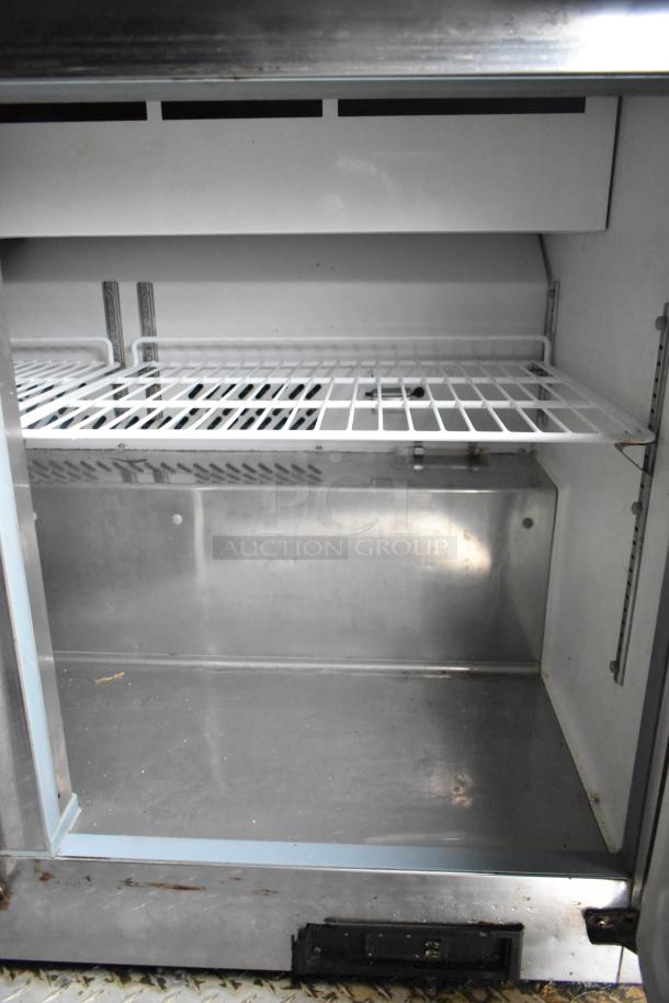 Interior of a Cruising Kitchens 24' food trailer showing a clean, spacious, commercial-grade stainless steel shelf.