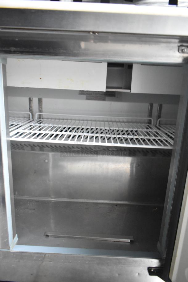Interior view of a Cruising Kitchens food trailer featuring a stainless steel shelving unit.