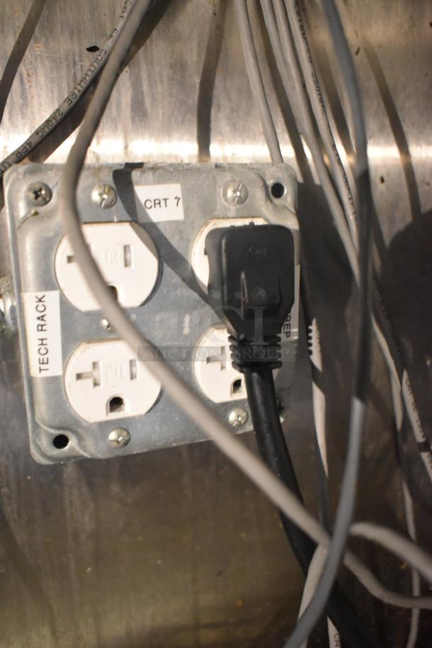 Electrical outlet panel inside a Cruising Kitchens food trailer, featuring labeled sockets marked "TECH RACK" and "CRT 7."