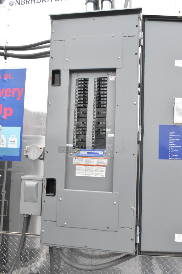 Electrical panel inside 2021 ATX 24' outfitted food trailer, featuring multiple circuit breakers and safety notices. Ideal for various business setups.