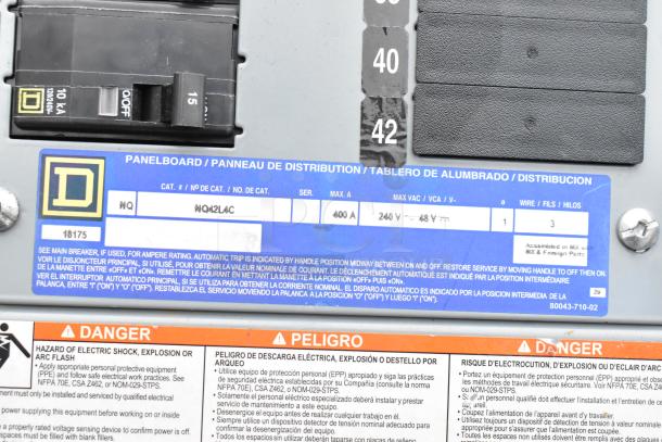 Panelboard showing a Square D 10 KA circuit breaker. Label indicates model NQ42L4C, 400 A, 240 V max. Safety warnings in English, Spanish, and French.
