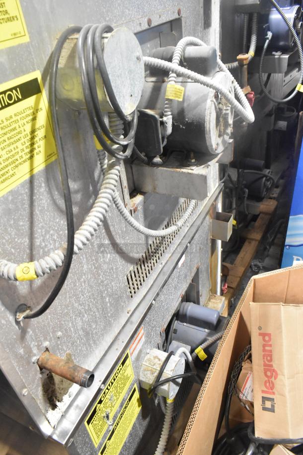 Back view of a Vulcan VC6GD-SEFCAM5 stainless steel commercial gas convection oven with visible wiring and caution labels.