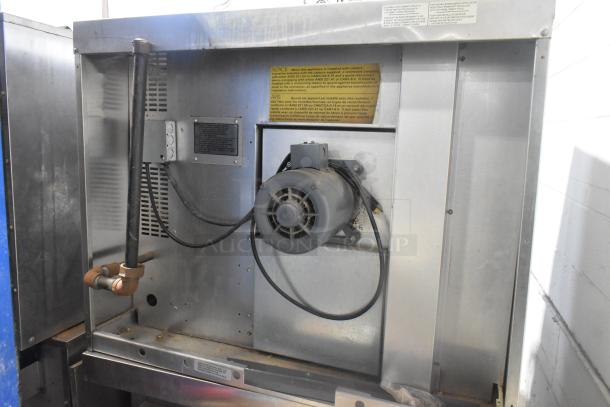 Stainless steel Duke convection oven rear view showing gas connection, fan, and wiring. In good condition with visible labels.