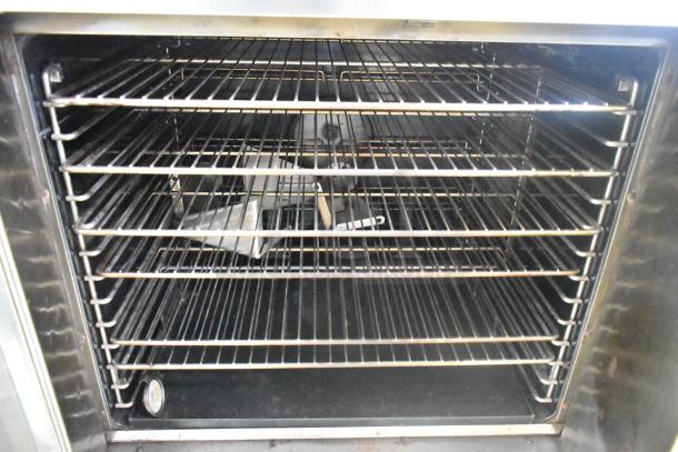 Duke stainless steel convection oven interior with multiple metal racks, gas powered, view-through door, thermostatic controls.