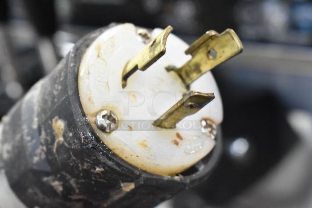 Close-up of a power plug for a Wellspring SSI-143S 220V soft serve ice cream machine, showing signs of use.