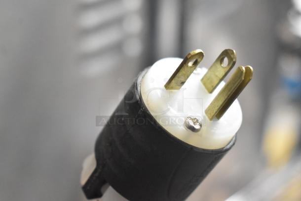 Close-up of a three-prong plug, indicating the 220-volt power requirement for the 2023 Sud Forni SPINELLO pizza oven.