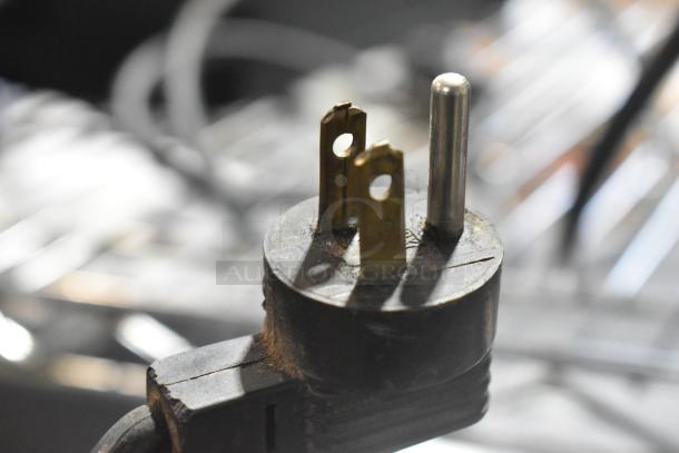 Close-up of a worn plug connected to a Gino Rossi RR45 Espresso Bean Grinder, highlighting its 120-volt power compatibility.