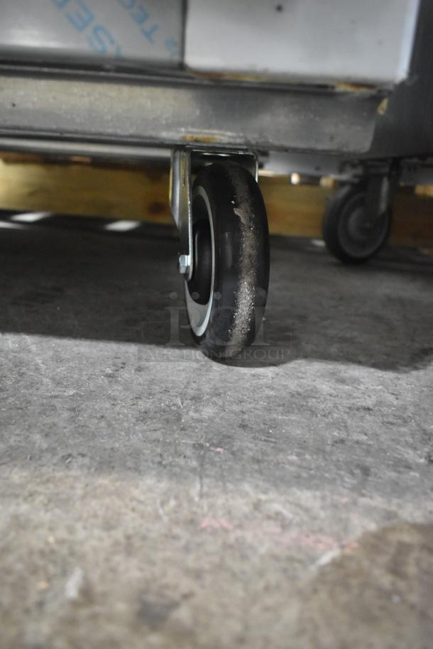 Cooltech CUST-48LB chef base caster close-up, stainless steel, commercial-grade, 115V, on concrete floor.