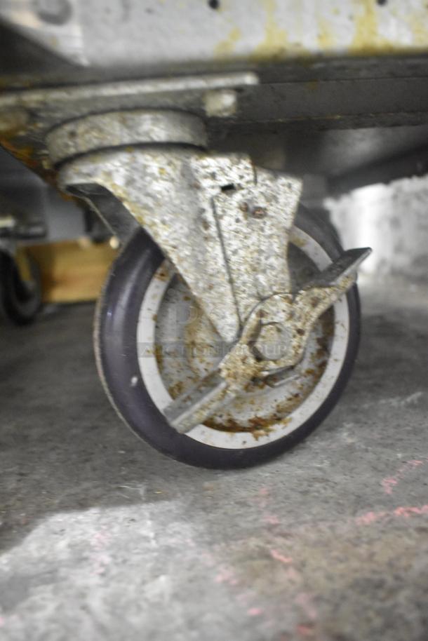 Rusted caster wheel of an American Range model AF-35/50 fryer. Steel construction, showing wear from use.