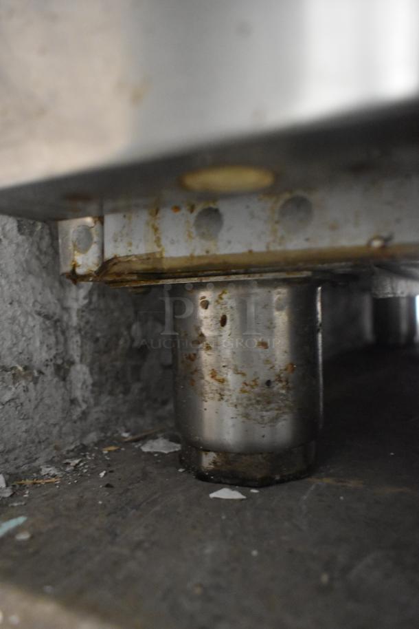 Aspes stainless steel commercial cooler leg, showing rust and wear. Undercounter model, 120/208 volts, 1 phase.